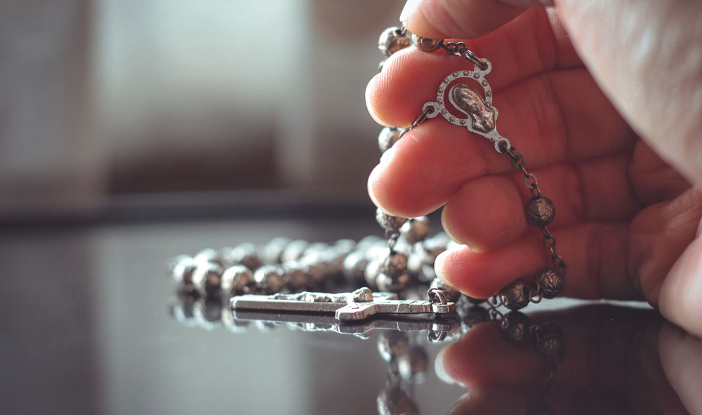 A hand holding a rosary