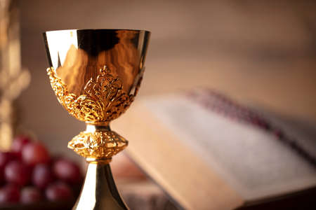 A chalice beside an open book